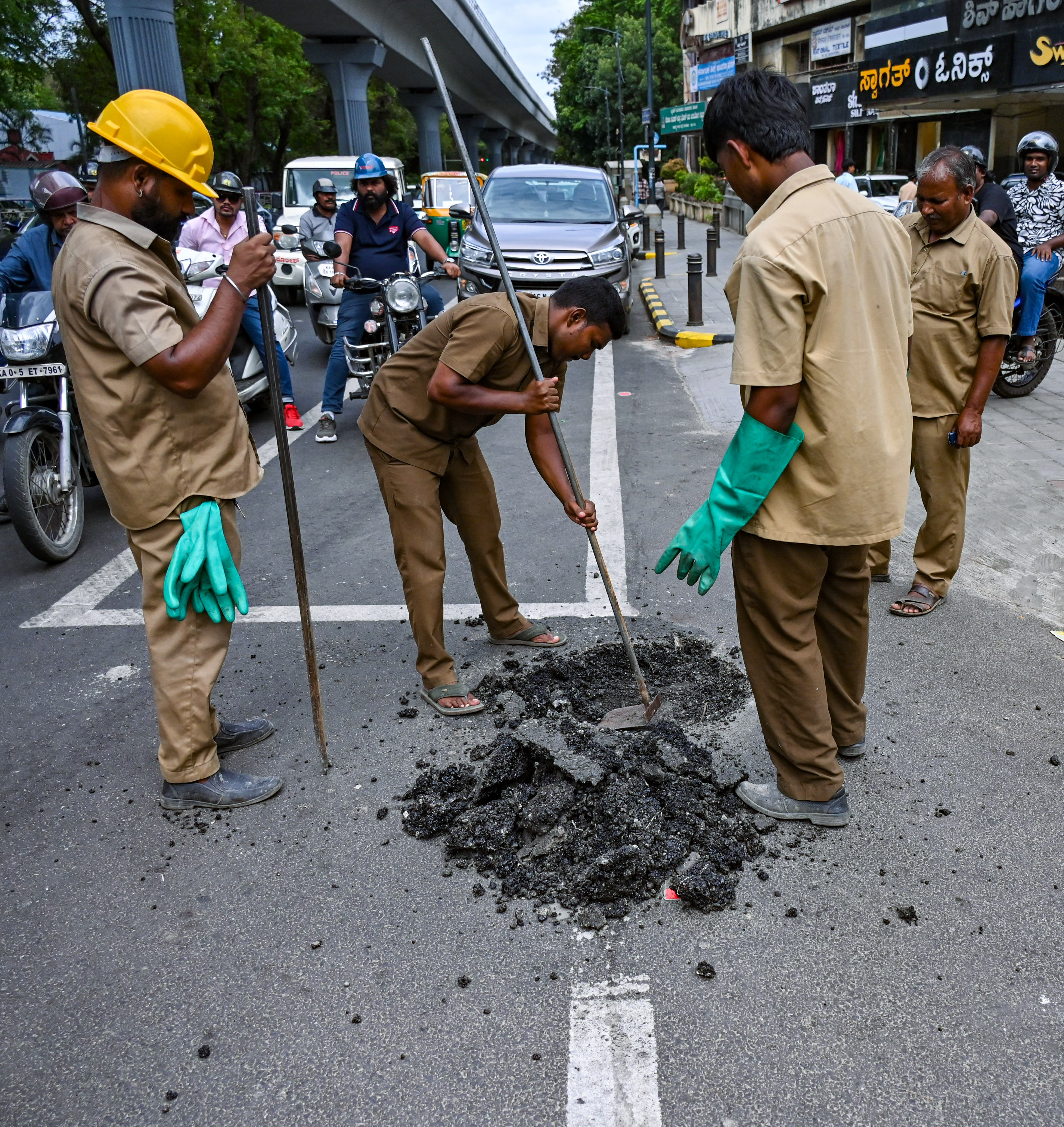 BWSSB workers dig up a freshly asphalted stretch on MG Road on Wednesday. DH PHOTO/PUSHKAR V