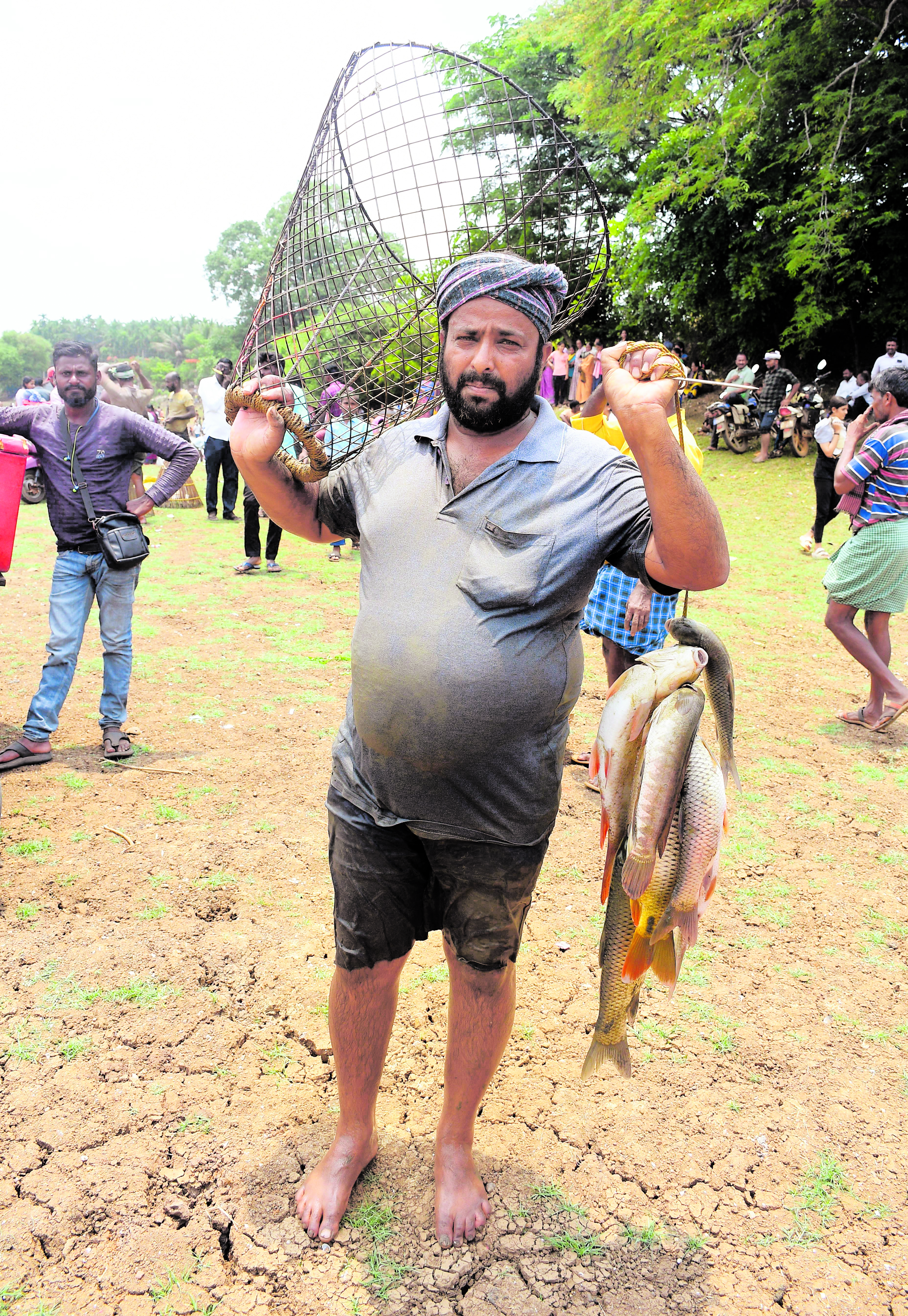 A man poses with the fish he caught in the Chittur Kere Bete. DH Photo/Shivamogga Nagaraj