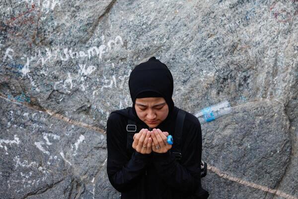 A Muslim pilgrim woman prays at Mount Al-Noor, where Muslims believe Prophet Mohammad received the first words of the Koran through Gabriel in the Hira cave.