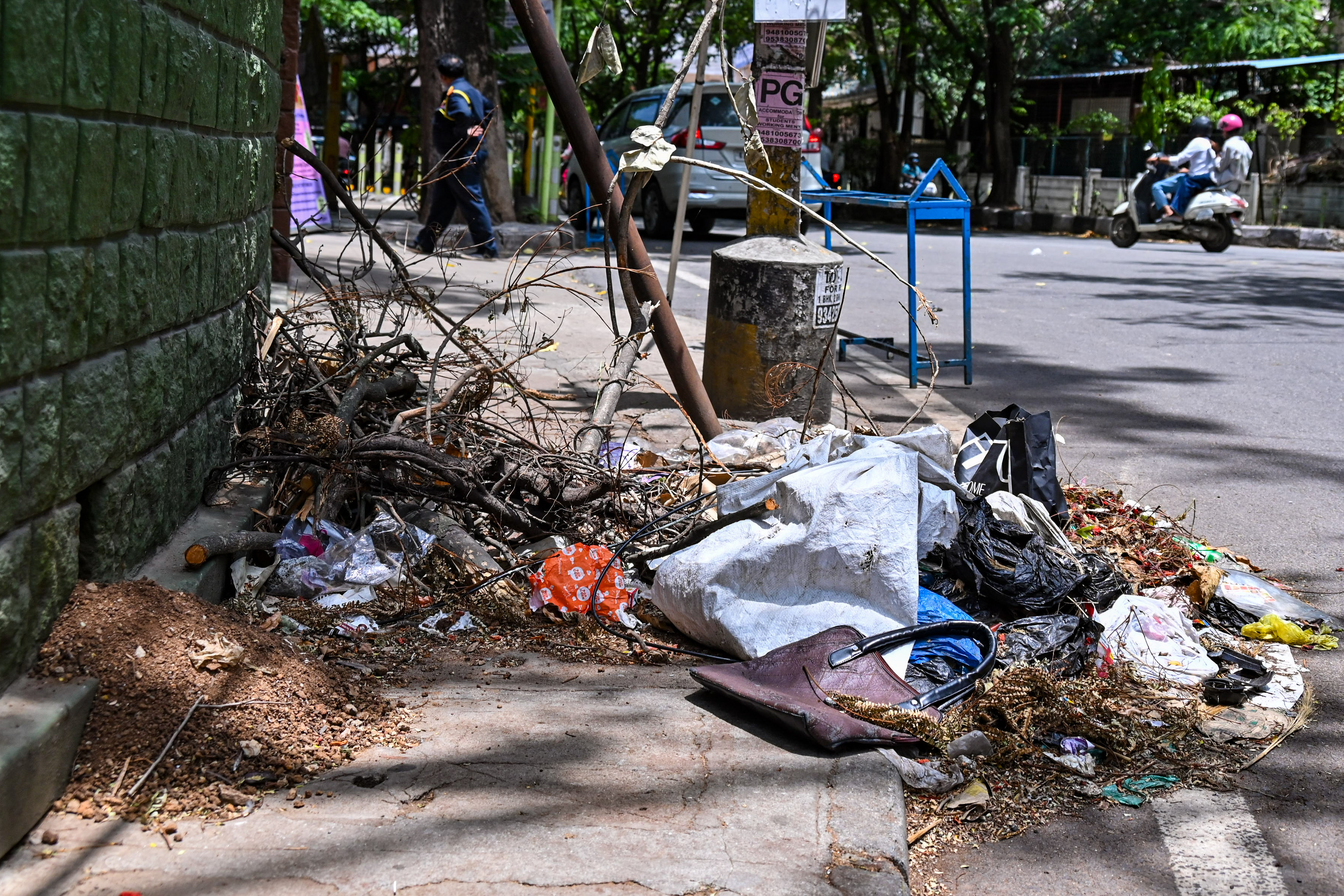 Uncleared garbage piles along a narrow footpath near Vivekananda Educational Centre in Jayanagar. 