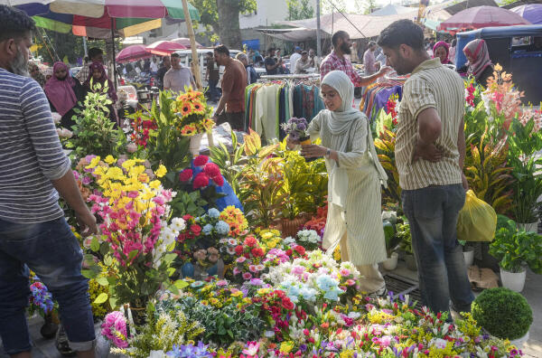 People shop for decorative artificial flowers amid preparations ahead of the ‘Eid ul-Adha’ festival, in Srinagar.