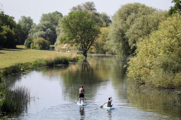 Paddle boarders on the River Great Ouse as temperatures climb over the bank holiday weekend during a heatwave, in Great Barford, Bedfordshire, Britain.