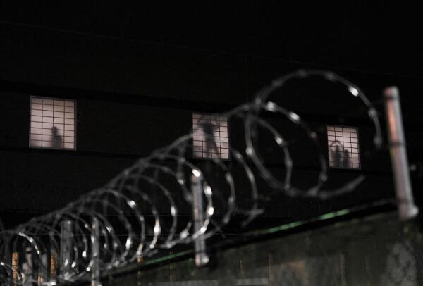 People wave from inside the US Immigration and Customs Enforcement (ICE) detention center Delaney Hall, to protestors gathered outside in efforts to block vehicle traffic from the detention center in support of a hunger strike going on inside among those detained, in Newark, New Jersey, US.