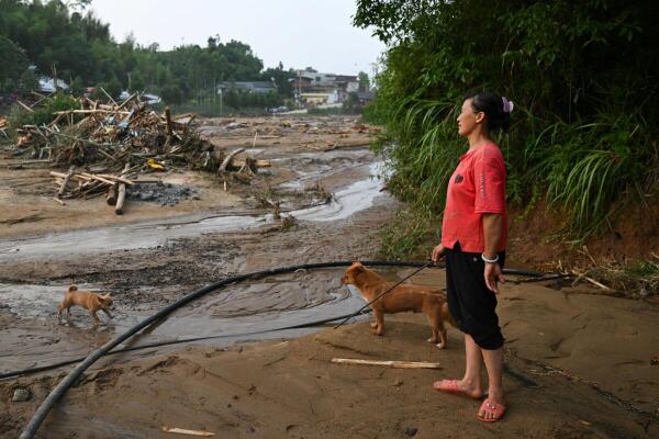 A resident stands near debris in Daqiao village following flash floods and landslides triggered by extreme rainfall, in Yongchuan district, Chongqing, China.