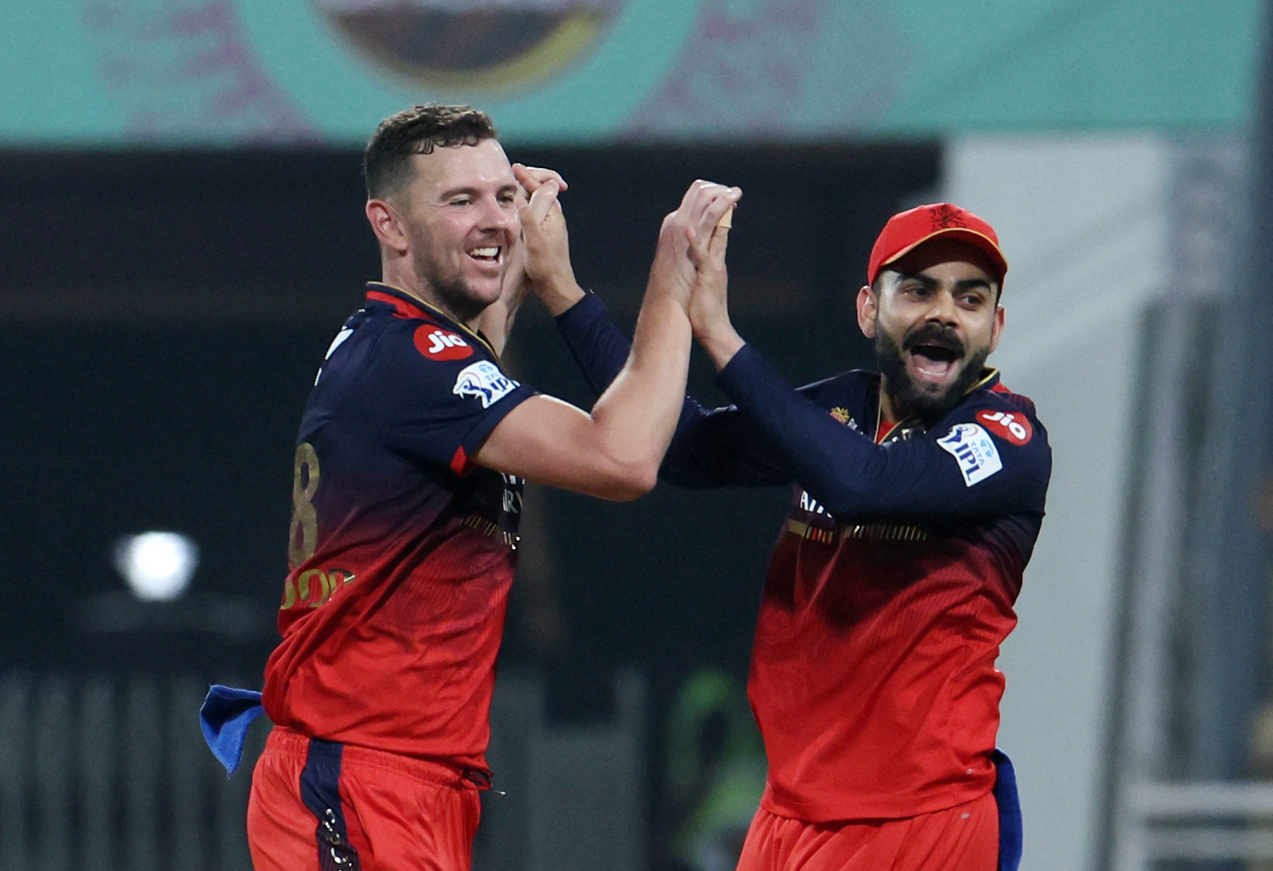 Josh Hazlewood (left) and Virat Kohli. 