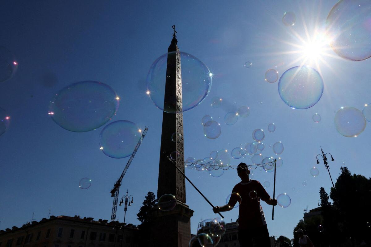 A person makes soap bubbles in Piazza del Popolo, in Rome, Italy.