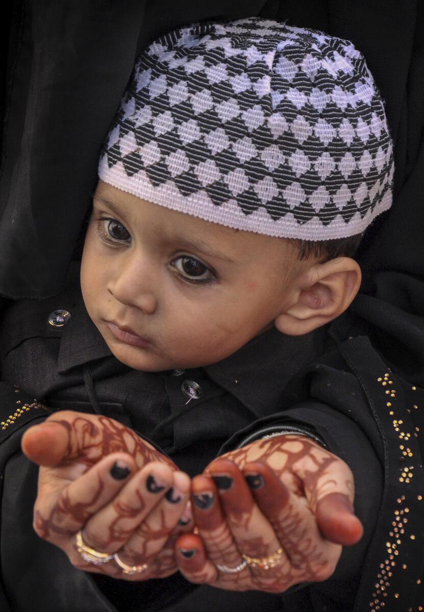 A woman with a child offers prayers on the occasion of Eid al-Adha at Jama Masjid Khairuddin, in Amritsar.