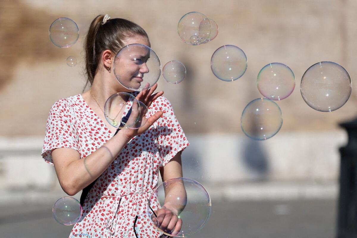 A woman reacts to soap bubbles in Piazza del Popolo, in Rome, Italy.