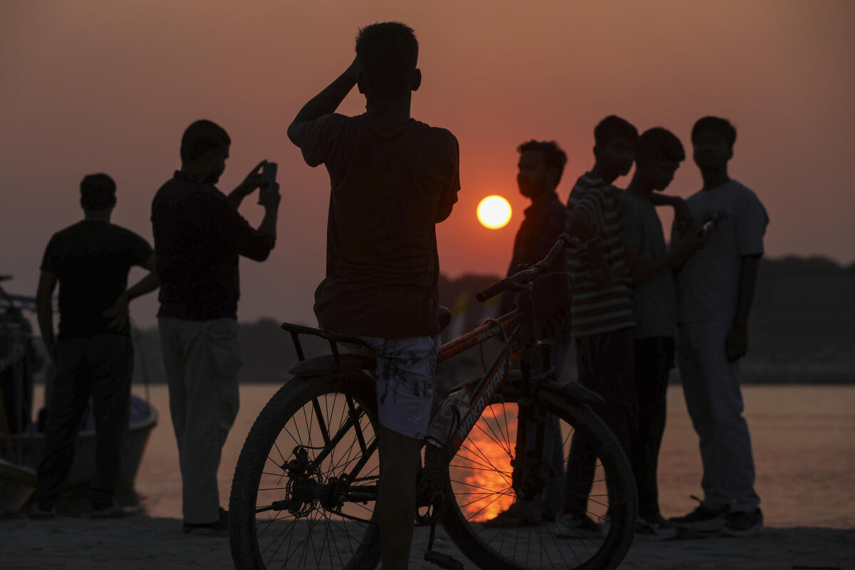 Silhouette of people standing at the bank of Sangam during sunset, in Prayagraj, Uttar Pradesh.