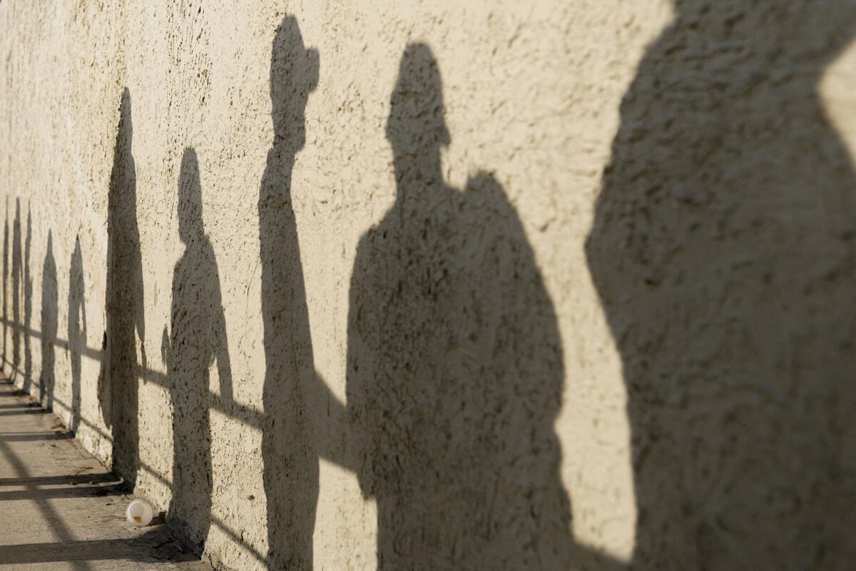 The shadows of people waiting outside a polling station to vote during the first round of the Colombian presidential election are cast on a wall, in Barranquilla, Colombia