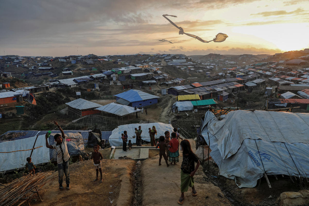 Rohingya refugees are reflected in rain water along an embankment next to paddy fields after fleeing from Myanmar into Palang Khali, near Cox's Bazar, Bangladesh November 2, 2017. REUTERS/Hannah McKay