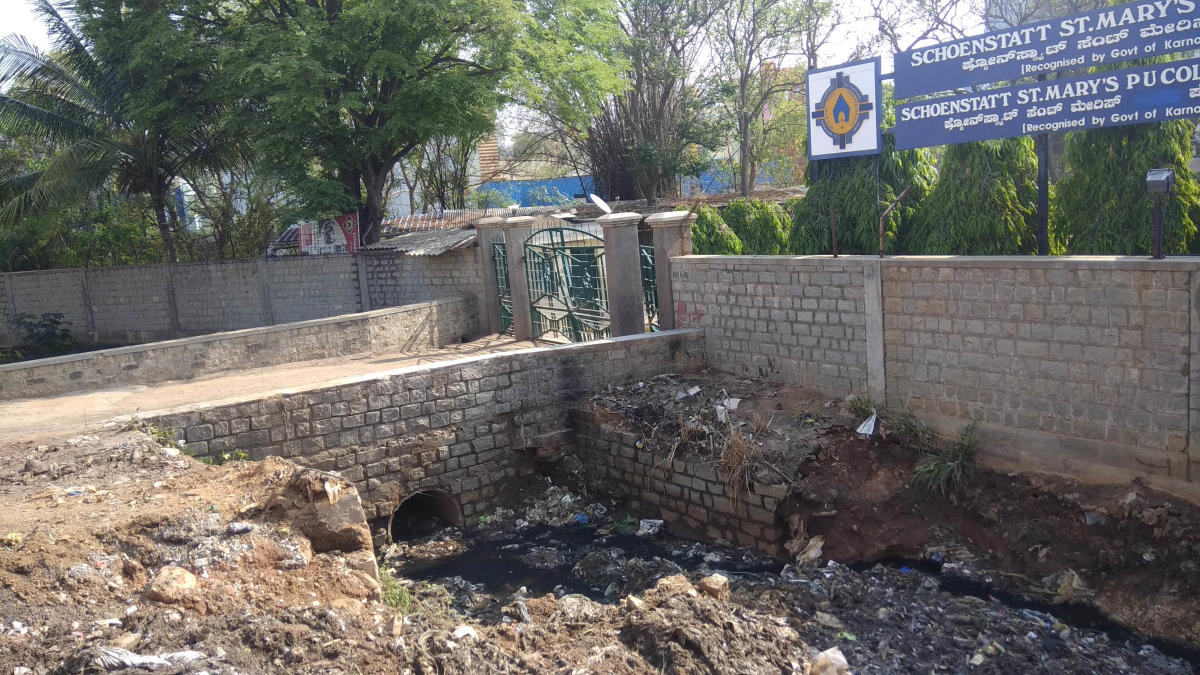 Teachers and Staff of St, Mary’s High School struggle to segregating which spoil by water from the drain floods the school premises at Rukmini nagar, T Dasarahalli damaging books and uniforms, in Bengaluru on Monday. Photo/ B H Shivakumar
