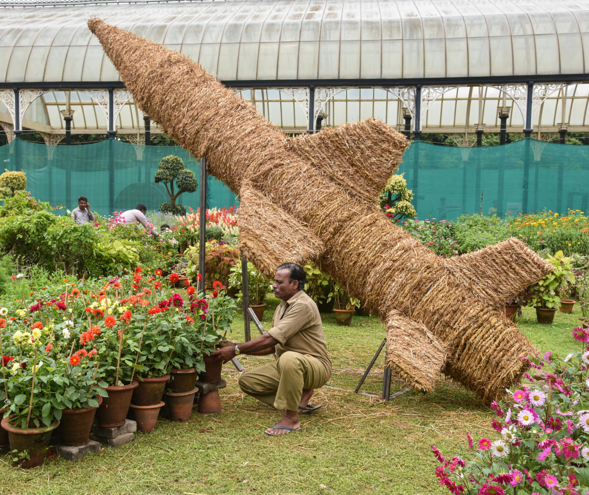 Workers preparing a floral model of a missile at the Lalbagh gardens on Thursday. The show will be on between August 4 and 15. DH Photo/S K Dinesh