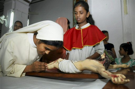 A nun kissing the feet of Jesus Christ during special prayer on the occasion of 'Good Friday' at St. Francis Church in Bhopal on Friday. PTI Photo