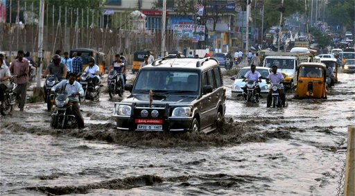 Vehicles wade through a waterlogged road after heavy rains in Hyderabad on Friday. PTI Photo