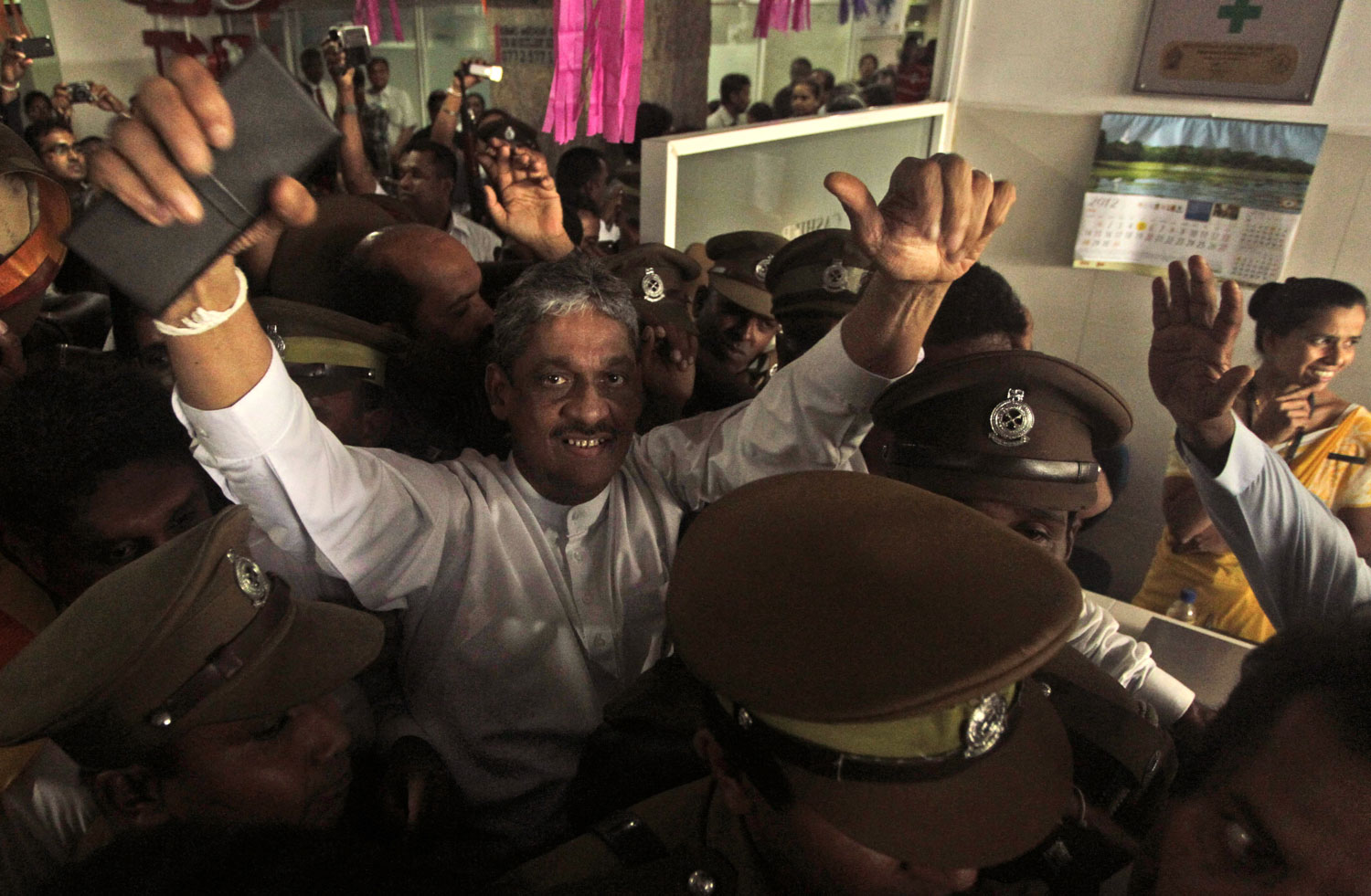 Sri Lankan former army chief Sarath Fonseka waves to his supporters as he is escorted out of a hospital in Colombo, Sri Lanka, Monday, May 21, 2012. Sri Lanka's President, Mahinda Rajapaksa ordered authorities to free the country's jailed former army...