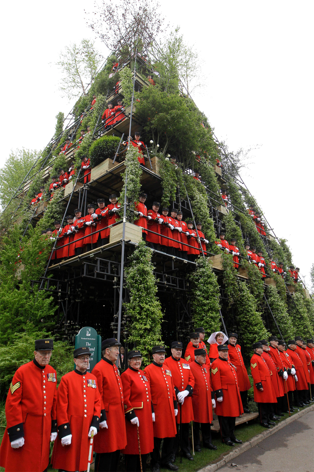 Chelsea pensioners look out from a show garden 'The Westland Magical Garden' designed by Diarmuid Gavin during the Chelsea Flower Show in London, Monday, May 21, 2012.