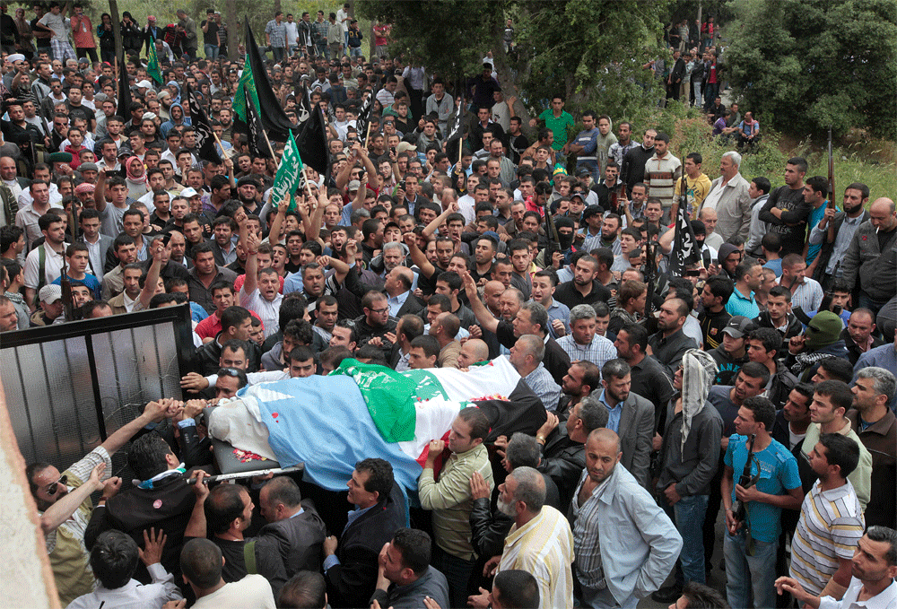 Mourners carry the body of anti-Syrian regime Sunni cleric Sheik Ahmed Abdul-Wahid, who was shot at a Lebanese army checkpoint, during his funeral procession, at his hometown village of Beireh, in Akkar north Lebanon, Monday, May 21, 2012. The circum...