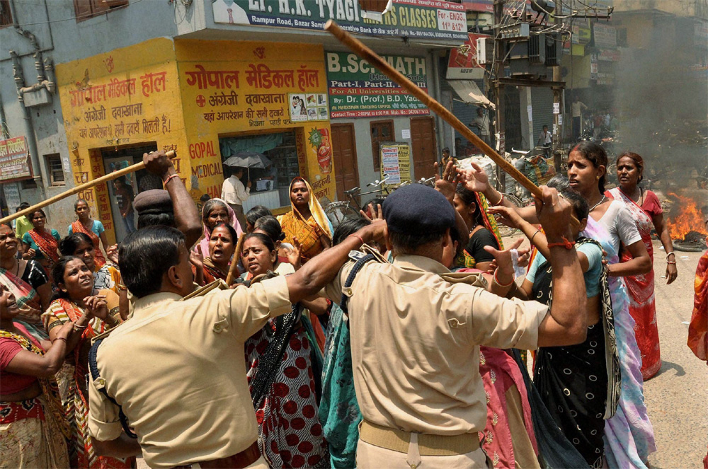 Patna: A policeman scuffles with women during a protest over alleged corruption in Municipal Corporation (PMC) elections in Patna on Monday. PTI Photo