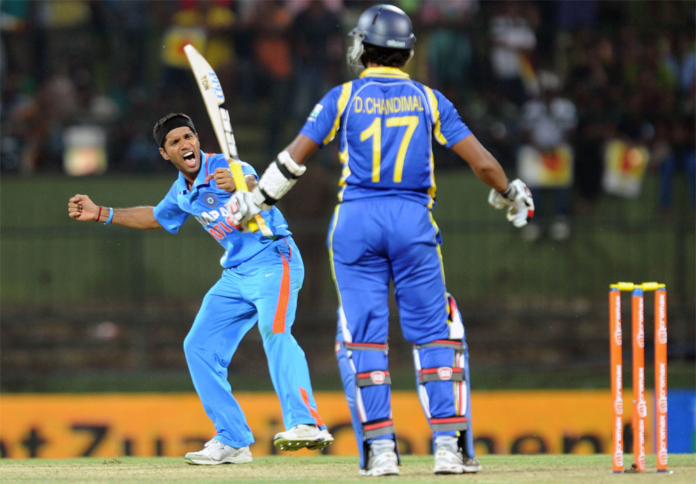 Indian cricketer Ashok Dinda (L) celebrates after dismissing Sri Lankan cricketer Dinesh Chandimal (R) during the fifth and final one-day international (ODI) match between Sri Lanka and India at the Pallekele International Cricket Stadium in Pallekel...