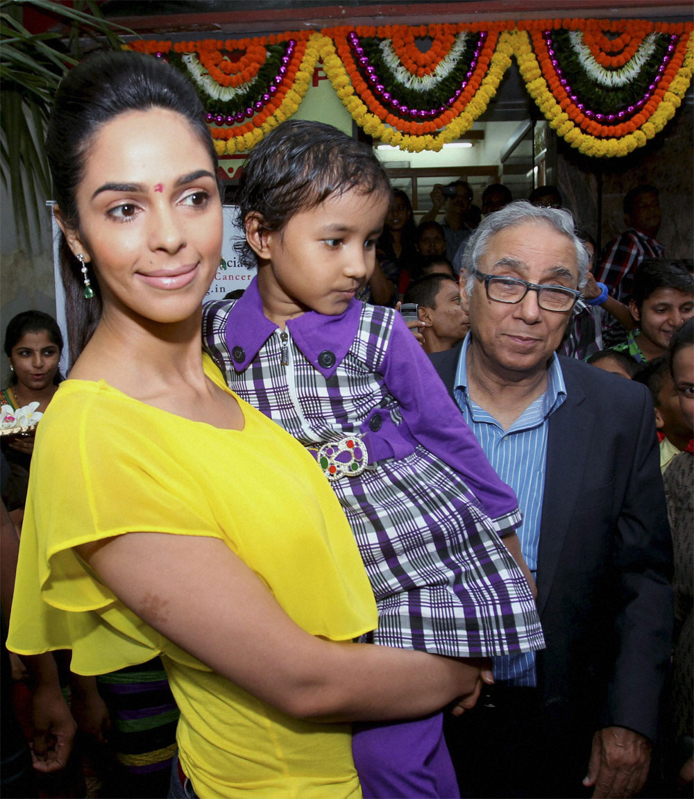 Acteess Mallika Sherawat holds a child as she celebrates Raksha Bandhan with the cancer patient children in Mumbai on Saturday. PTI 