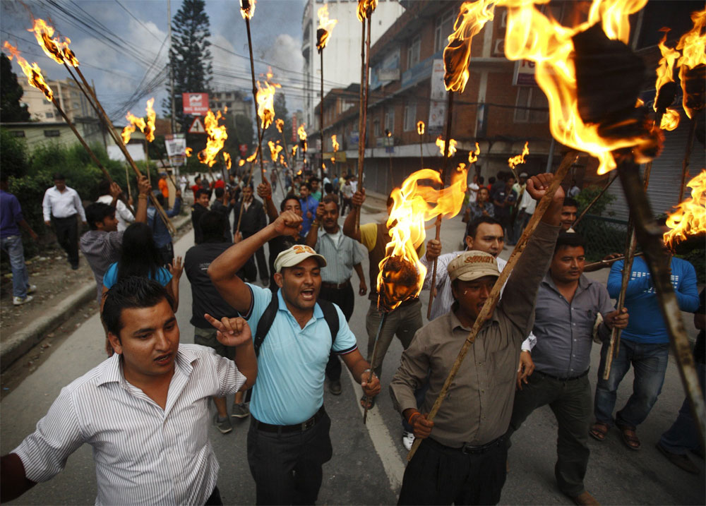 Activists of the Communist Party of Nepal Unified Marxist Leninist (CPN-UML) affiliated Youth Association Nepal shout slogans during their torch rally to demand the immediate resignation of Prime Minister Baburam Bhattarai in Kathmandu August 4, 2012...