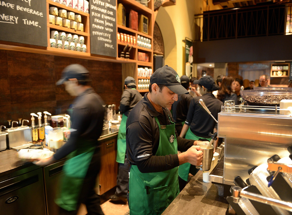 Staff work behind the counter of India's first newly-inaugurated Starbucks outlet in Mumbai on October 19, 2012. Starbucks, the world's biggest coffee chain, launched its first Indian outlet on October 19 in an upscale part of Mumbai, becoming the la...