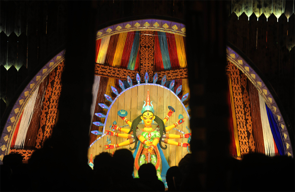 Indian visitors look at an idol of Hindu goddess Durga in preparation  for the upcoming Hindu festival Durga Puja in Siliguri on October 18,  2012. The five-day period of worship of Durga, who is attributed as the  destroyer of evil, commences on Oct...
