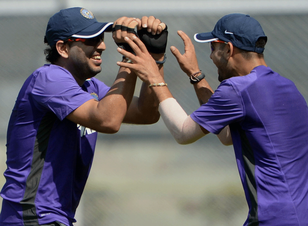 Yuvraj Singh (L) and Virat Kohli share a light moment during a training session on the second day of a three day camp at the Cricket Club of India (CCI) in Mumbai on November 10, 2012. The Indian cricket team has opted for a three day training camp a...