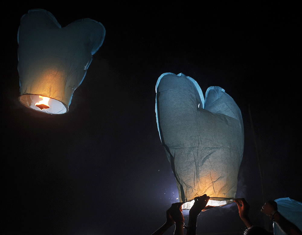 Indian volunteers of a social organisation release a sky lantern to promote a peaceful and eco-friendly Diwali, and create awareness against child labour in the fire cracker industry during a function in Kolkata on November 9, 2012. The Diwali the Fe...