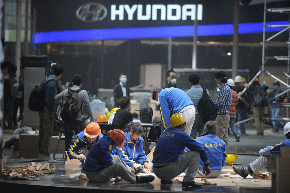 n this photo taken on April 17, 2013 workers build the Hyundai stand at  the Shanghai New International Expo Center ahead of China's premier car  show which opens April 21 in Shanghai. Global manufacturers will flock  to China for the Shanghai Auto S...