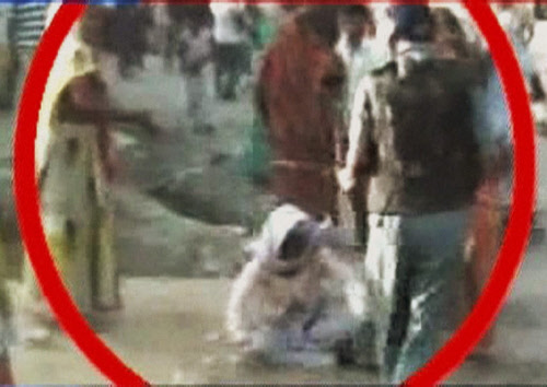 An old woman who was thrashed by a police man during a demonstration over the alleged rape and murder of a six-year-old girl in Aligarh, Uttar Pradesh on Thursday. PTI Photo