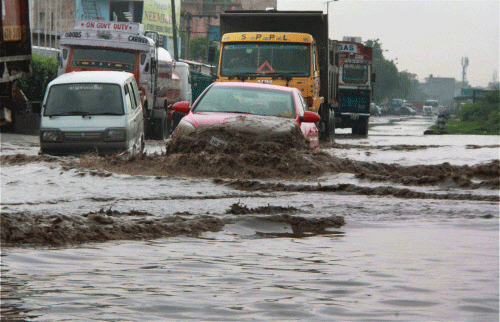 Vehicles move at a waterlogged road after heavy rains in Gurgaon on Thursday. PTI Photo