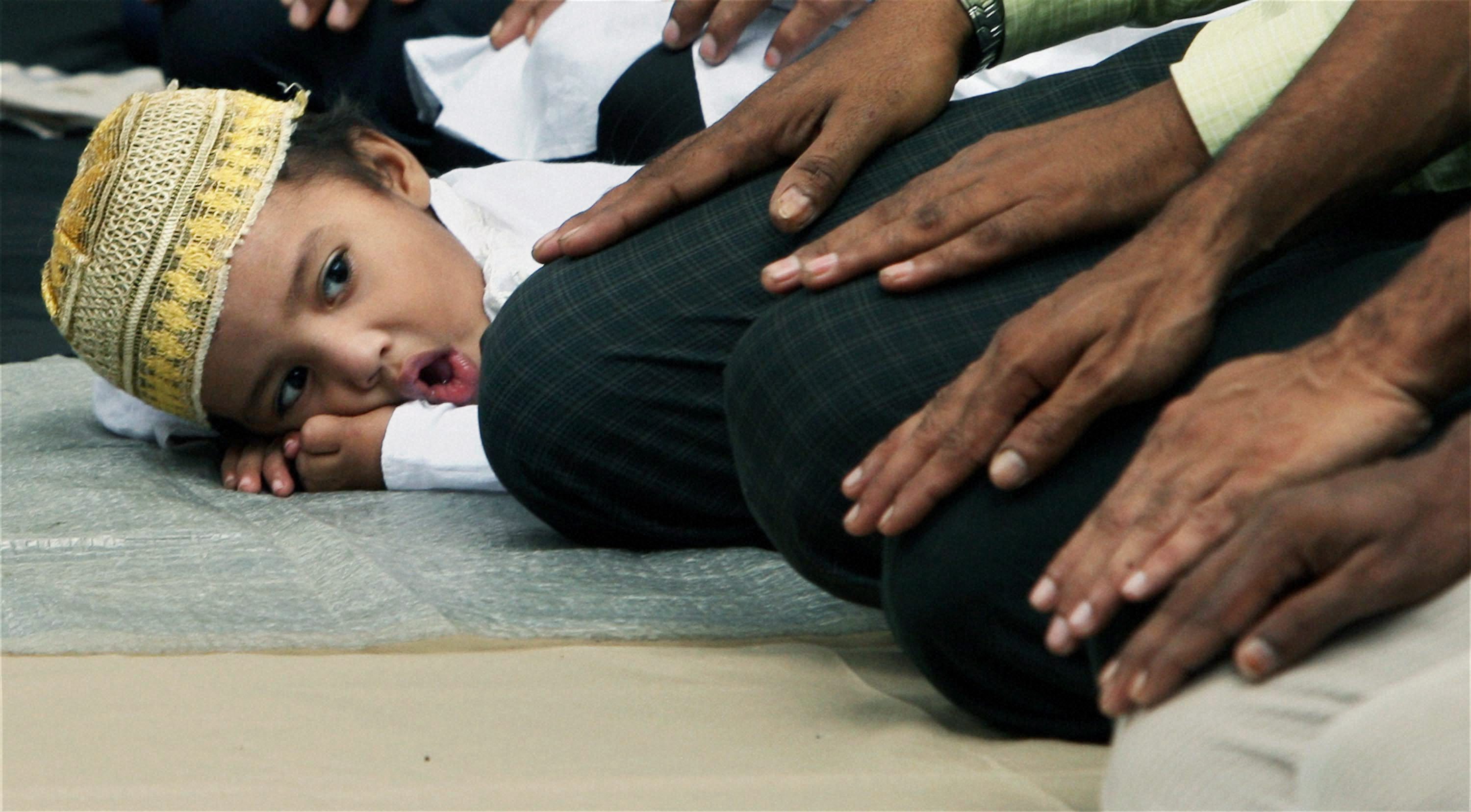 A Muslim boy follows the elders offering Friday prayers on the road in front of Tipu Sultan Mosque in Kolkata during the holy month of Ramadan. PTI Photo