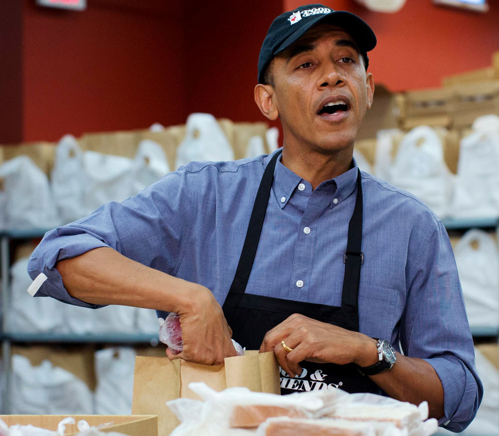U.S. President Barack Obama prepares bags of food alongside volunteers at 'Food and Friends' community service facility in Washington, September 11, 2013. REUTERS/