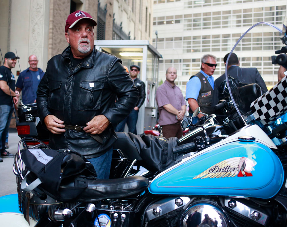 Singer Billy Joel gets off a motorcycle after riding from the Rescue 1 firehouse on West 43rd Street downtown to Ground Zero to honor the victims of the 9/11 attacks, outside the World Trade Center site in New York September 11, 2013. Bagpipes, bells...