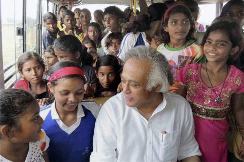 Union Minister for Rural Development Jairam Ramesh travel in a bus with tribal girls during his visit at a village near Ranchi on Thursday. PTI Photo