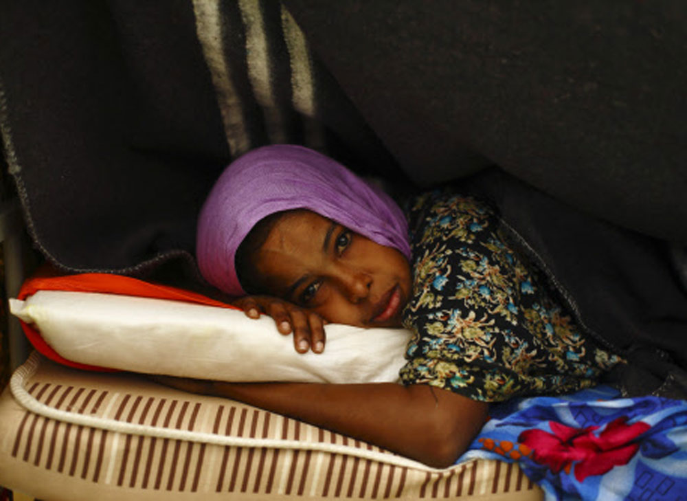 A Somali migrant lies on her bed in a dormitory at the Lyster barracks detention centre for immigrants in Hal Far Reuters Image