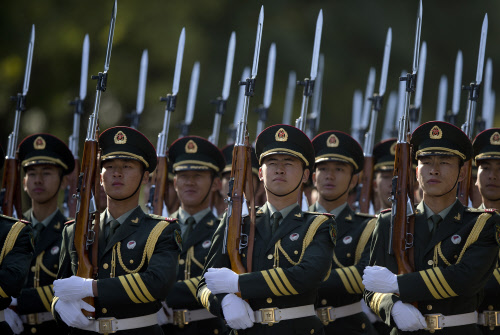 Members of a guard of honor march as they prepare for a welcome ceremony for visiting Prime Minister Manmohan Singh outside the Great Hall of the People in Beijing Wednesday, Oct. 23, 2013. China and India signed a confidence-building accord Wednesda...