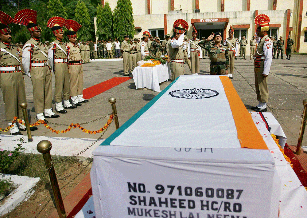 Jammu: BSF officers pay tributes near the coffin of soldier Mukeshlal  Meena, who was killed in RS Pura Sector in the firing from Pakistan  side, during a wreath laying ceremony in Jammu on Wednesday. PTI Photo