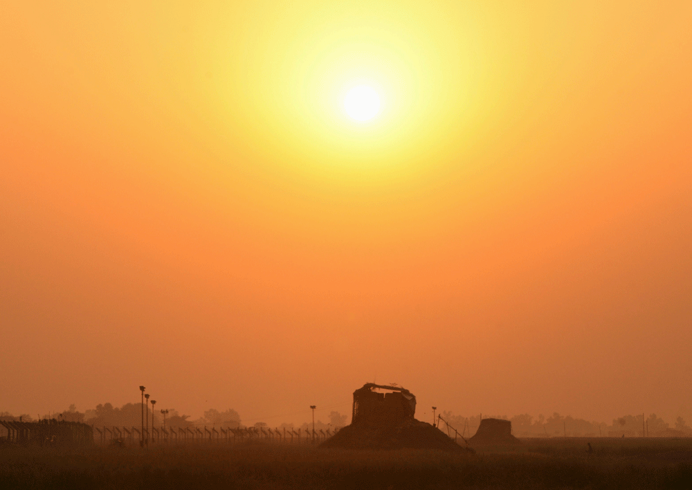 Security pickets are silhouetted against the setting sun at the border with Pakistan in Suchetgarh, southwest of Jammu October 23, 2013. An Indian Border Security Force (BSF) soldier was killed and three others were injured in Jammu region after firi...