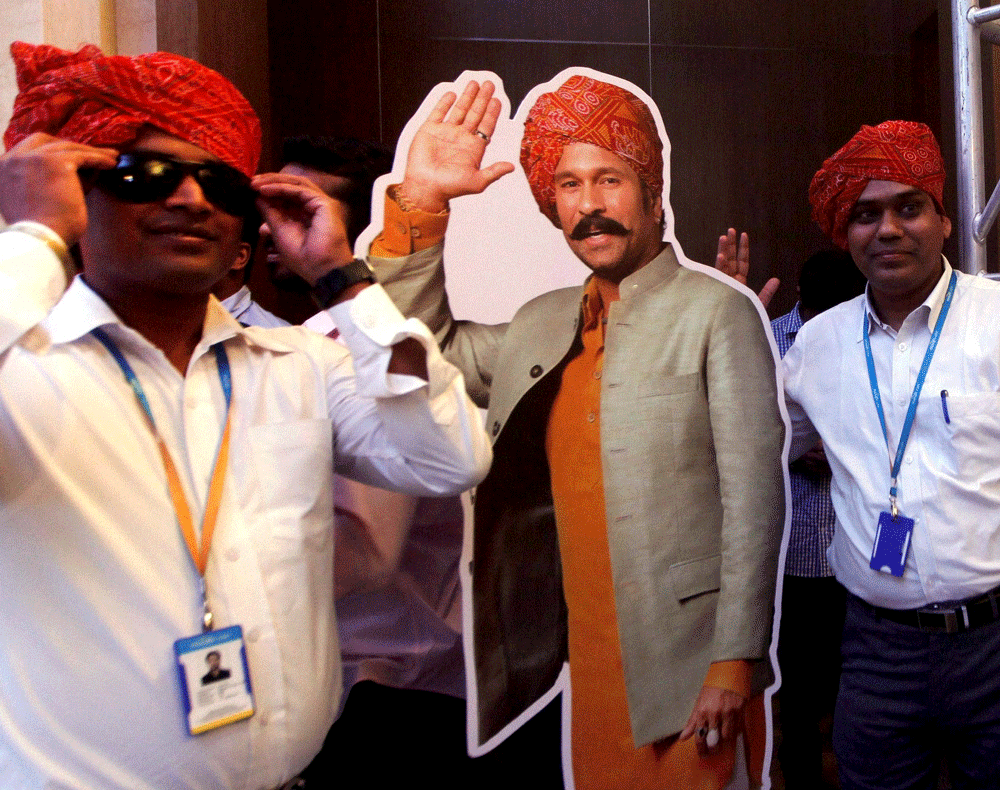 Master blaster Sachin Tendulkar's fans pose with his cutout at a news conference where he launched a travel portal in Mumbai on Wednesday. PTI Photo
