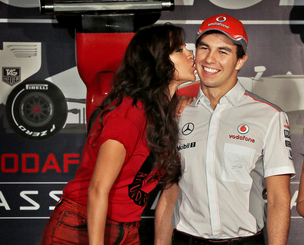 Neha Dhupia kisses McLaren Formula One driver Sergio Perez of Mexico during a promotional event in New Delhi on Wednesday. PTI Photo