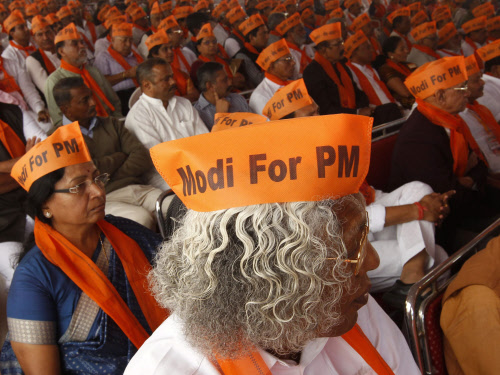 Workers of India's main opposition Bharatiya Janata Party (BJP) wearing saffron Gandhi caps, attend their party's meeting addressed by Hindu nationalist Narendra Modi, prime ministerial candidate for BJP and Gujarat's chief minister, after Modi inaug...