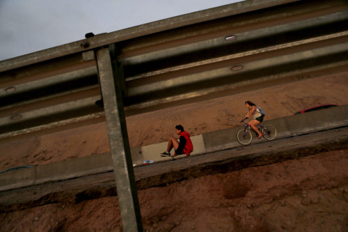 Residents cycle and skateboard along a damaged road to Alto Hospicio  commune after an earthquake and tsunami hit the northern port of Iquique  April 2, 2014.  Chilean authorities on Wednesday were assessing the  damage from a massive earthquake that...