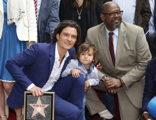 Actor Orlando Bloom of Britain (L) poses with his son Flynn and actor  Forest Whitaker after receiving a star on the Hollywood Walk of Fame in  Hollywood, Los Angeles, California April 2, 2014. REUTERS