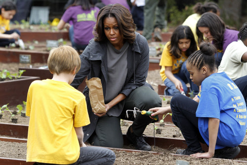 U.S. first lady Michelle Obama and local schoolchildren plant the sixth  annual White House Kitchen Garden in Washington April 2, 2014. Michelle  Obama planted a vegetable garden on the South Lawn to initiate a  national conversation around the healt...
