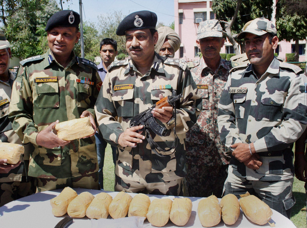 Amritsar: BSF officers and jawans display 13 kgs of heroin recovered from Mullakot Outpost in Amritsar on Thursday. PTI Photo