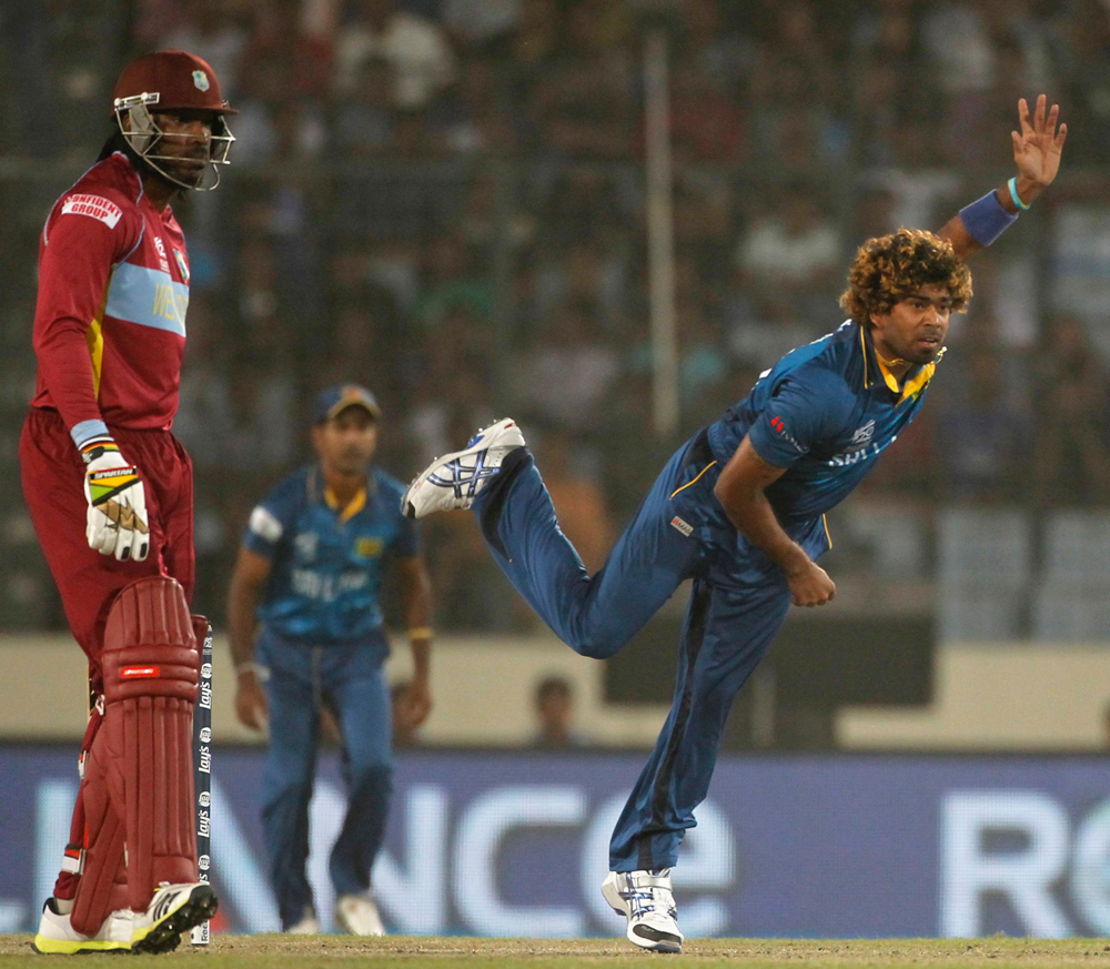 Sri Lanka's Lasith Malinga bowls as West Indies' Chris Gayle (L) watches during their semi-final match in the ICC Twenty20 World Cup at the Sher-E-Bangla National Cricket Stadium in Dhaka April 3, 2014. REUTERS/Andrew Biraj (