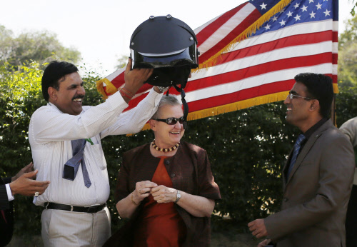 .S. Chuadhary, a senior official of Mumbai Police, holds a bomb-proof helmet as U.S. ambassador to India Nancy Powell, smiles during a presentation of Explosive Ordnance Disposal Suits, Helmets and Disruptors to the Mumbai Police at a function in the...